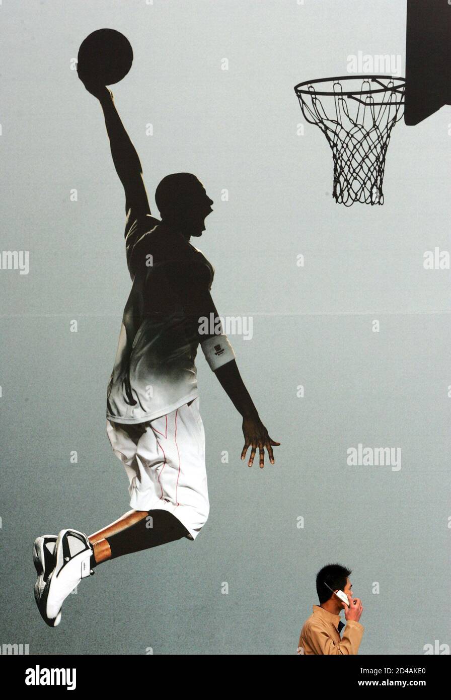 896x1390  Китайский мужчина проходит мимо огромной рекламы обуви иностранных брендов с участием звезды НБА Трейси МакГрэйди в Пекине. Китайский мужчина проходит мимо огромной рекламы баскетбольных туфлей иностранных брендов