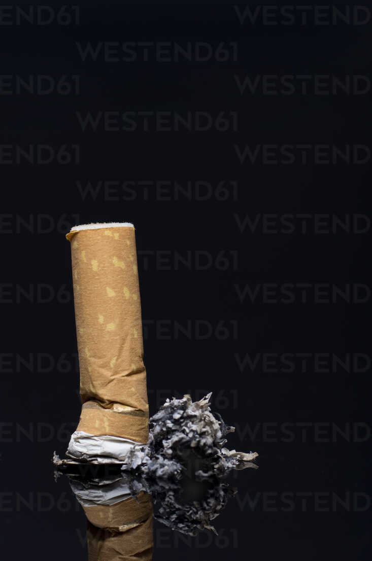 733x1106  Сгоревшая сигарета с пеплом на черном фоне, крупным планом Stock Photo
