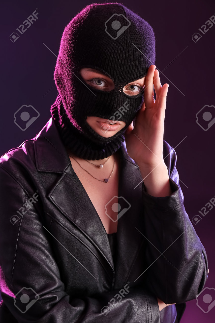 867x1300  Молодая женщина в балаклаве и кожаная куртка с рукой рядом с темным фоном Stock Photo, Picture и Free Listerty. Изображение 192168951.