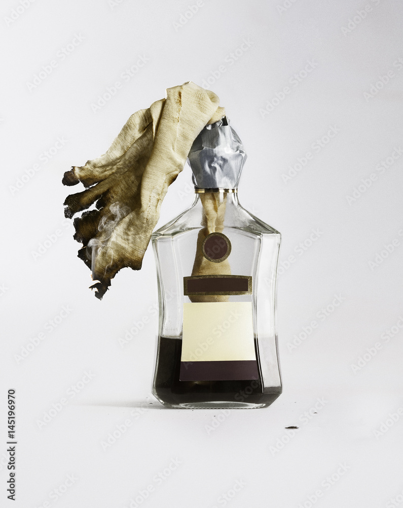 795x1000  Коктейль Молотова. Зажигательная смесь в бутылке коньяка на белом фоне. Stock-foto | Adobe Stock