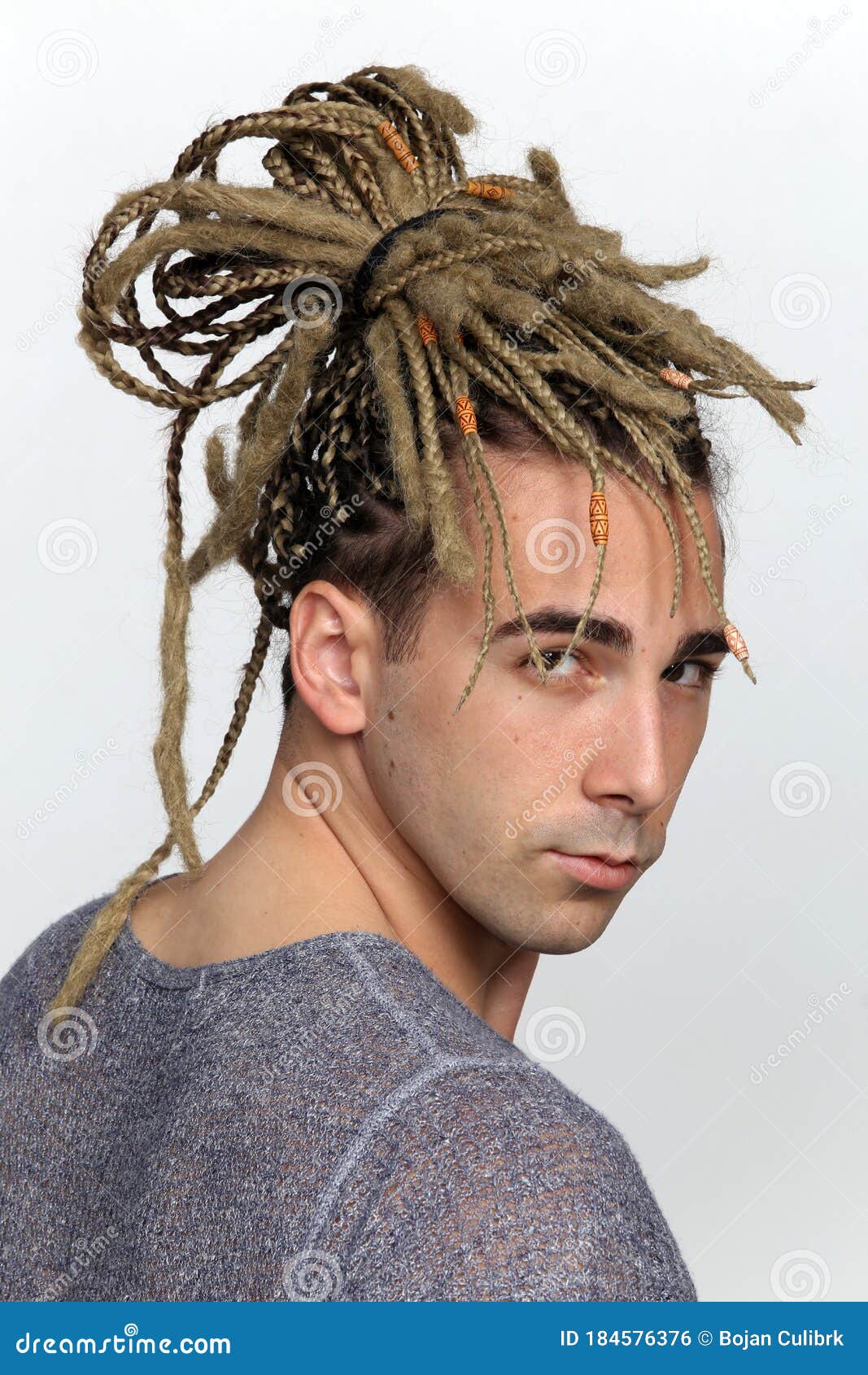 1067x1690  Привлекательная блондинка мужская модель с комбинацией косичек и дреда, позирующих в студии на изолированном фоне. Сток -фото - изображение страхов, красивое: 184576376