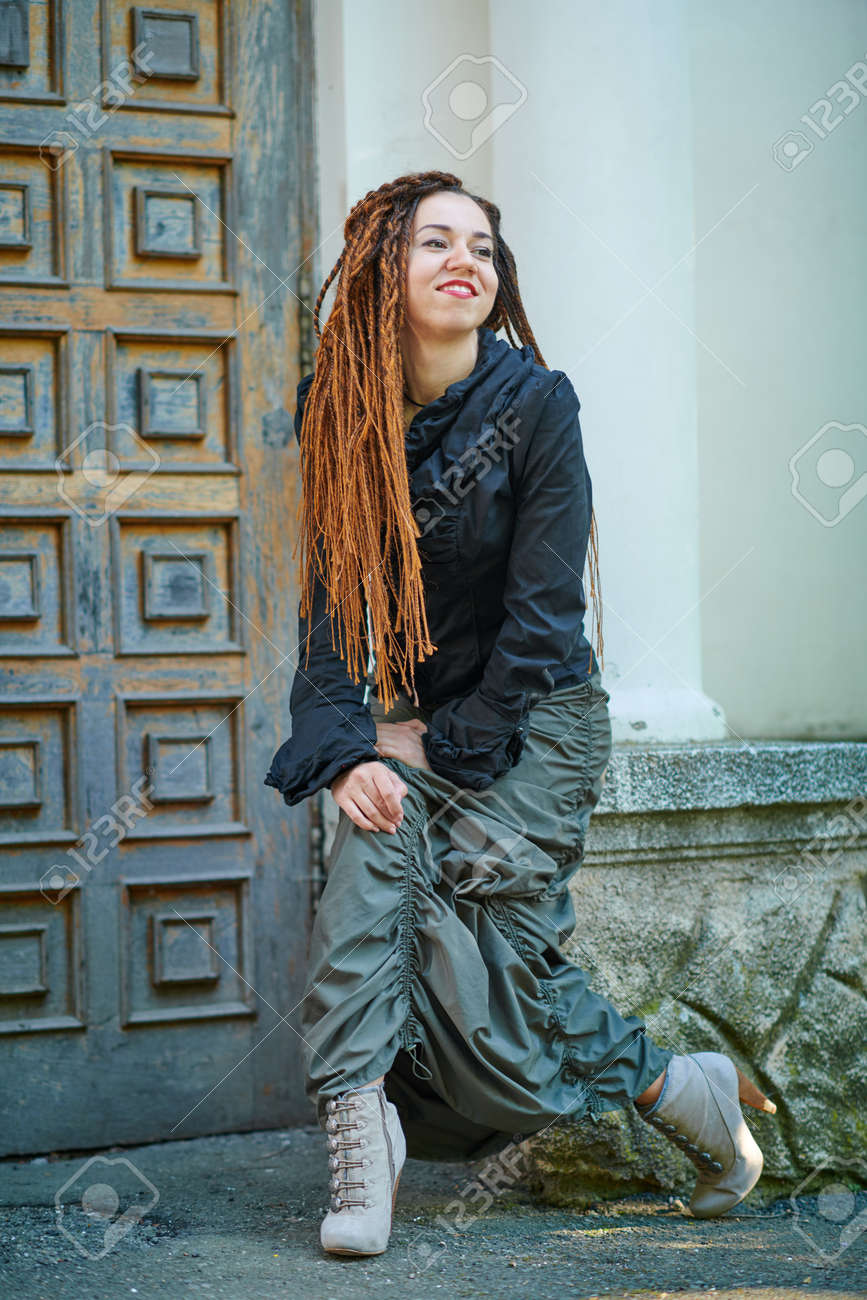867x1300  Dreadlocks Fashionable Girl, позирующая на старом деревянном фоне двери Stock Photo, Picture и REALITCY Image. Изображение 125059030.