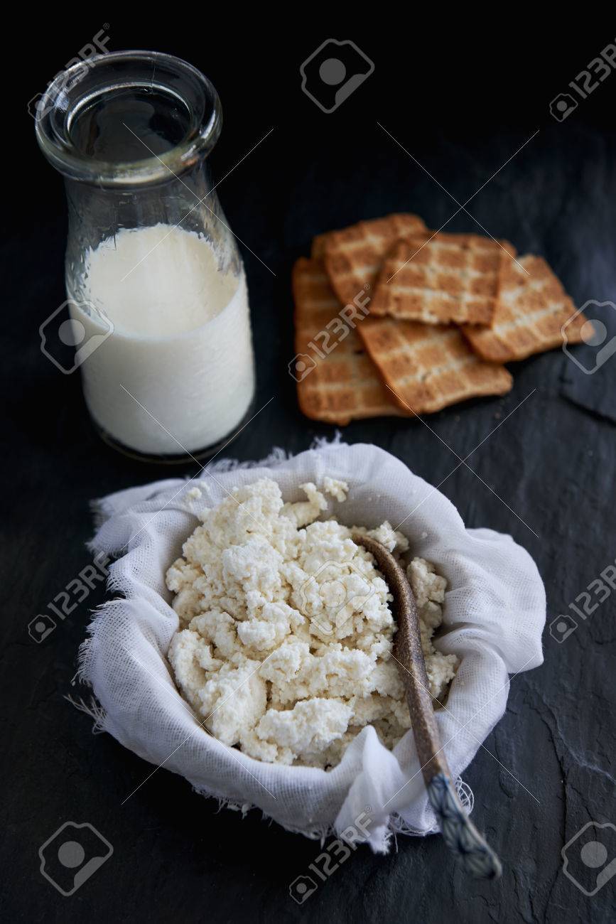 867x1300  Домашний творог, истощающий в муслино -сырной ткани с основным ингредиентом молоком на темном фоне, изображение, картинки и изображение без роялти. Изображение 44451856.