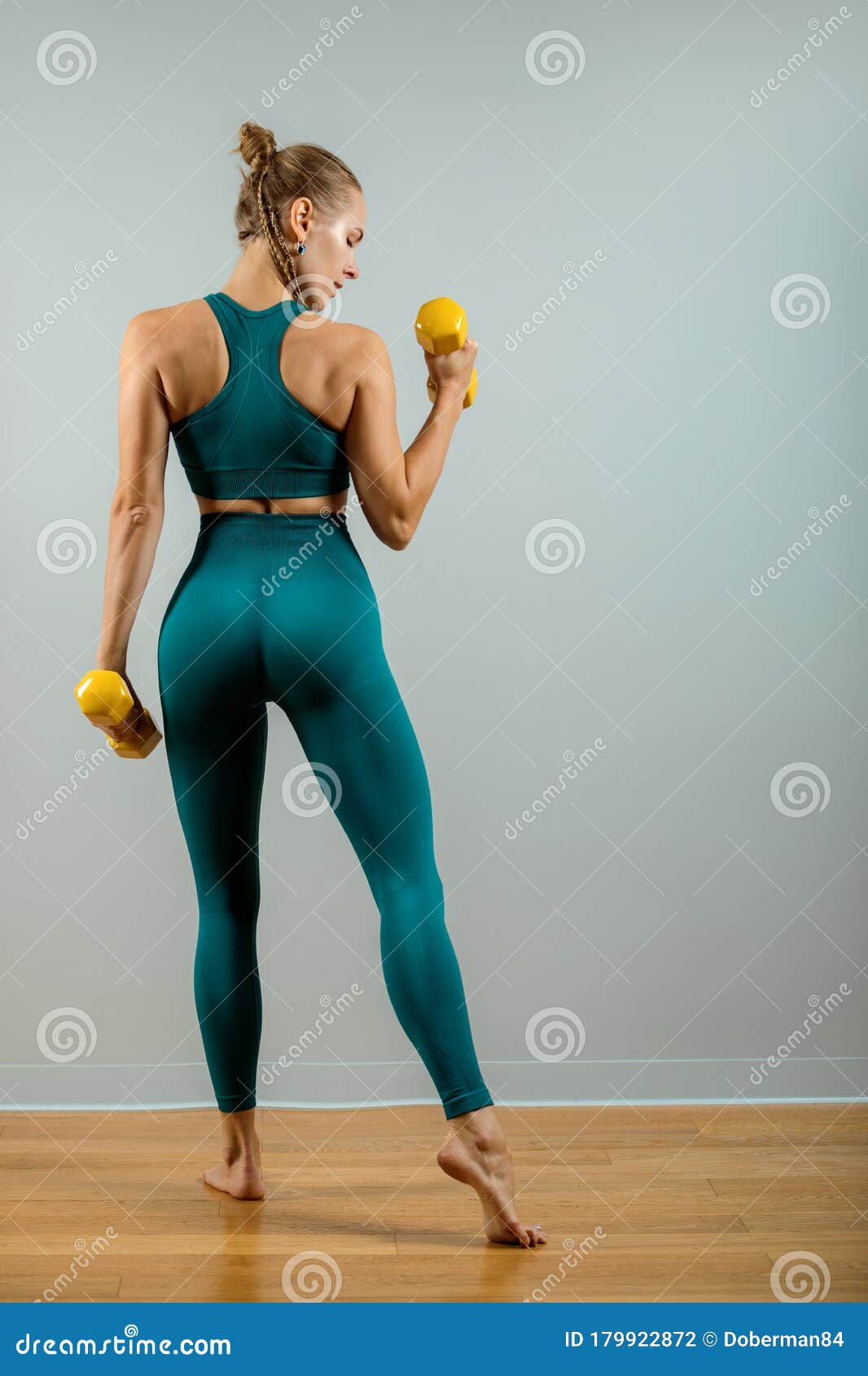 1066x1690  Подходящая женщина поднимает вес. Красивая фитнес -девушка на сером фоне, позирующем с гантелями на сером фоне Stock Photo - изображение подъема, люди: 179922872