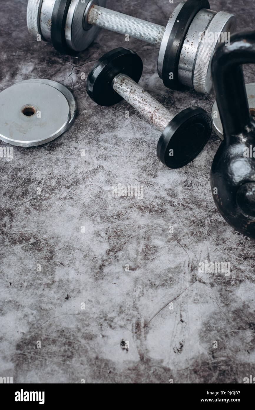 866x1390  Фитнес или бодибилдинг. Старые железные гантели и гири на сером, конрете в спортзале. Вид сверху. Здоровье Стоковое фото - Alamy