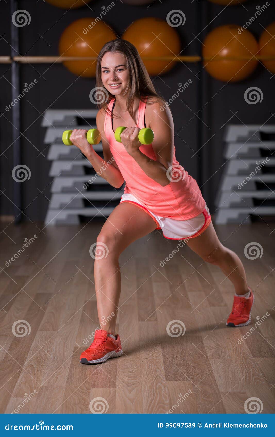 1067x1690  Красивая, девушка с гантелями. Активная, молодая спортивная женщина на размытом в спортзале. Фитнес -стиль концепции. Стоковое изображение - изображение милого, счастливое: 99097589
