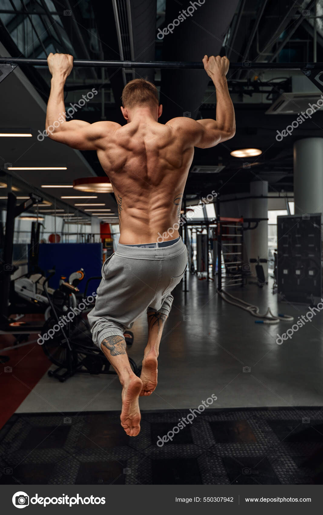 1067x1700  Мускулистый сильный человек, занимающийся спортивным тренажерным залом, человек делает горизонтальные отжимания с барами в спортзале. Фоновый тренажерный зал с пространством копирования. Сток -фото от © gerain0812 550307942