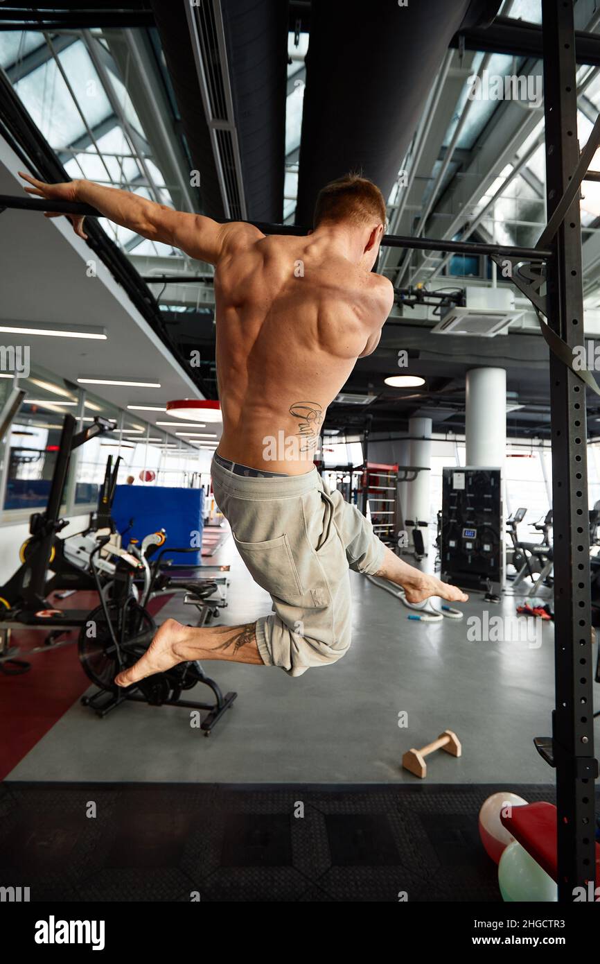 866x1390  Мускулистый сильный человек, занимающийся спортивным тренажерным залом, человек делает горизонтальные отжимания с барами в спортзале. Фоновый тренажерный зал с копией пространства Стоковое фото - Алами