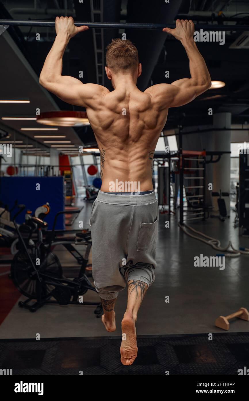 866x1390  Мускулистый сильный человек, занимающийся спортивным тренажерным залом, человек делает горизонтальные отжимания с барами в спортзале. Фоновый тренажерный зал с копией пространства Стоковое фото - Алами