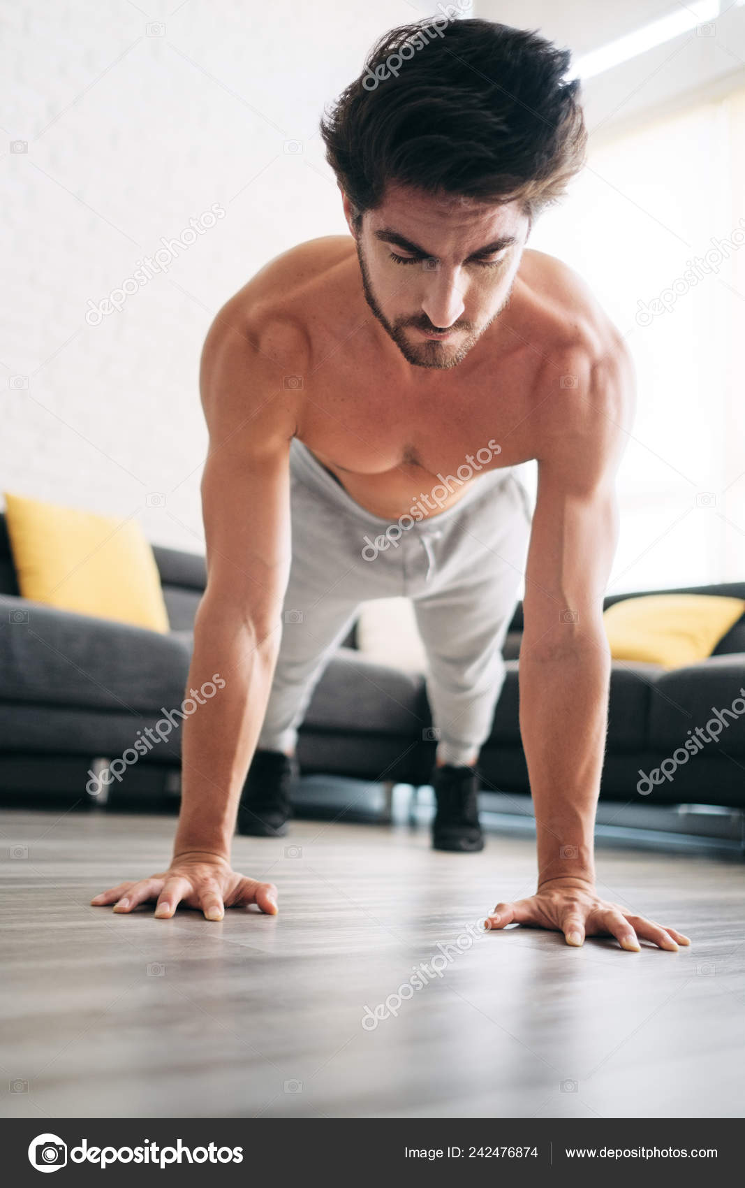 1067x1700  Взрослый мужчина тренирует мышцы груди дома, делая отжимания-фото
