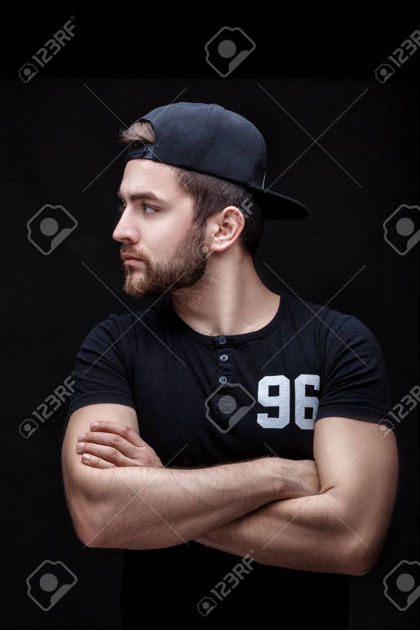 866x1300  Портрет красивого молодого человека в черной рубашке и кепке на черном фоне. Рэппер Стоковой Фото, изображение и роялти. Изображение 74193072.
