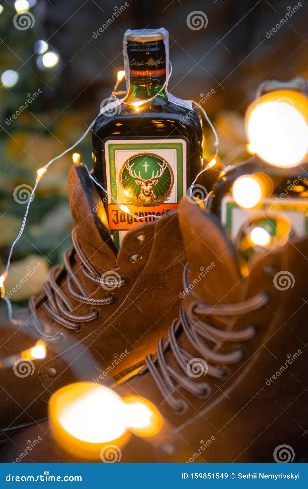 1067x1690  С Новым годом или Рождеством с алкогольными напитками Jagermeister, Elixir. Новые годовые гирлянды, кожаные зимние ботинки как редакционное изображение - изображение фруктов, фон: 159851549