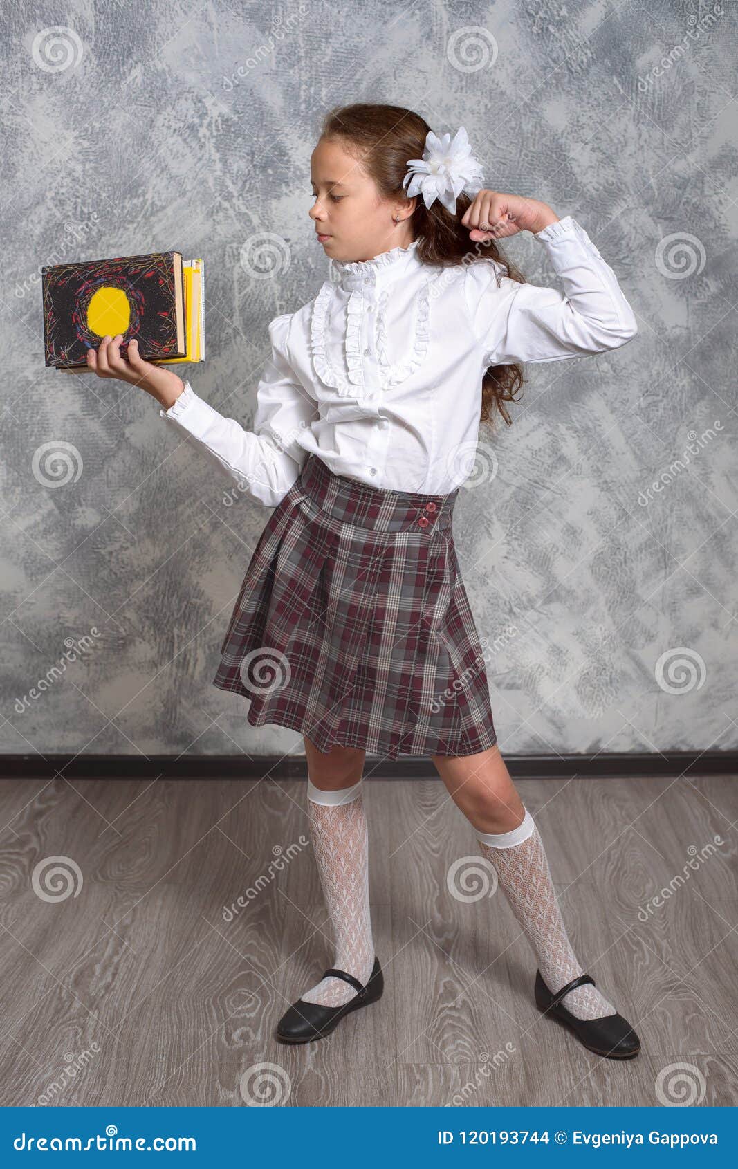 1067x1690  Школьница в школьной форме с книгами и учебниками позирует на светло -сером фоне. Концепция обучения детей. Сток -фото - изображение Happy, книга: 120193744