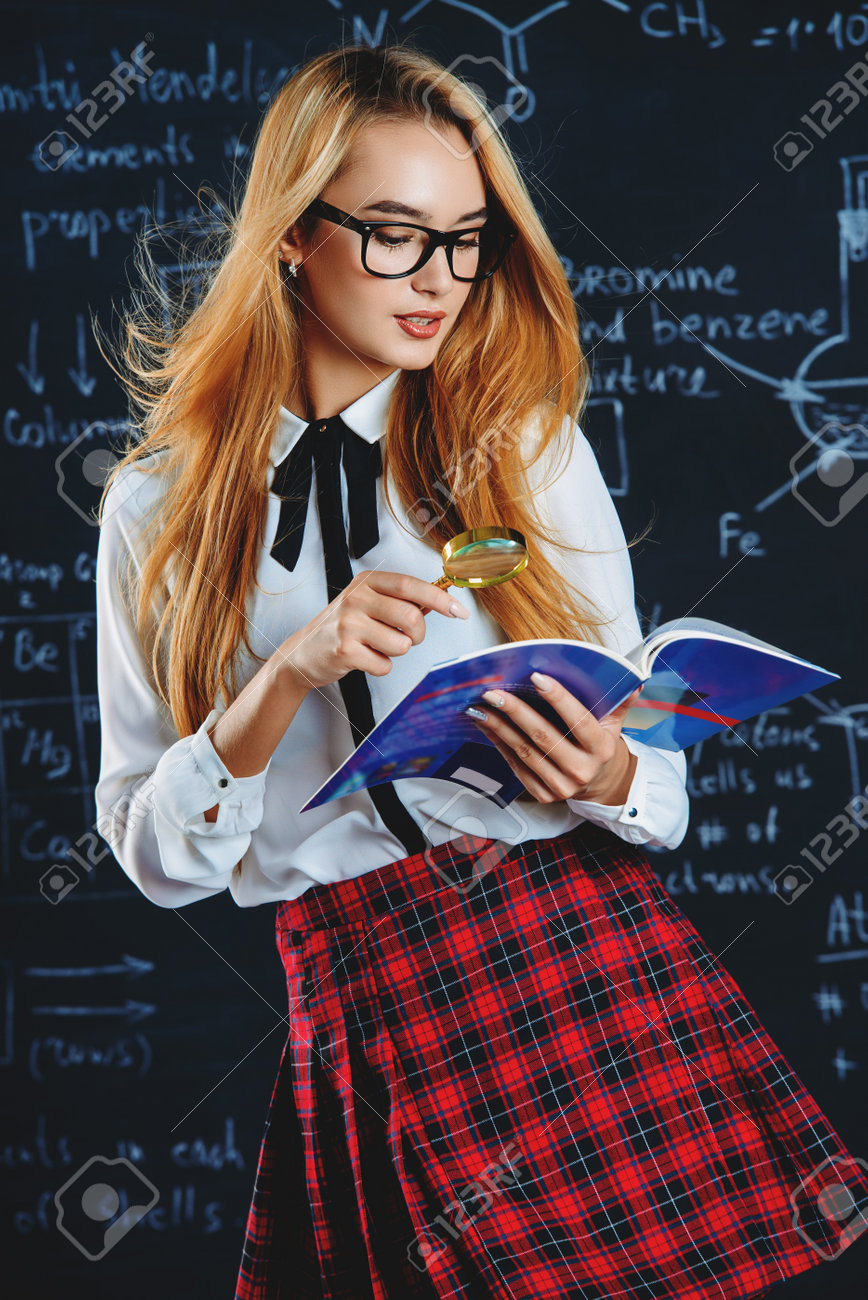 868x1300  Симпатичная ученица с длинными светлыми волосами, позирующими в школьной форме и очками на фоне доски. Сток -фото, картинки и роялти. Изображение 87514735.