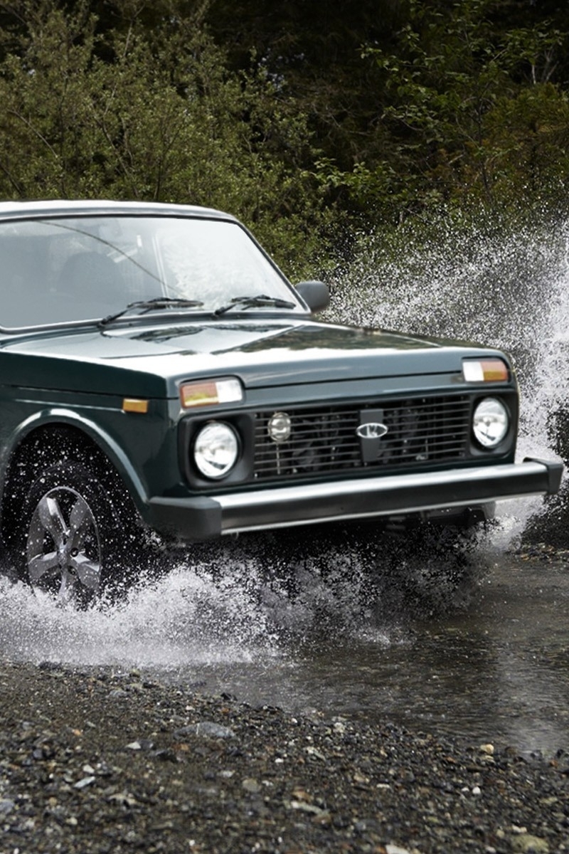 800x1200  Скачать обои и картинки ваз, лада, нива, lada, niva 4x4, едет, дорога,  трасса, брызги, вода, фары, колёса, деревья для рабочего стола в разрешении  800x1200