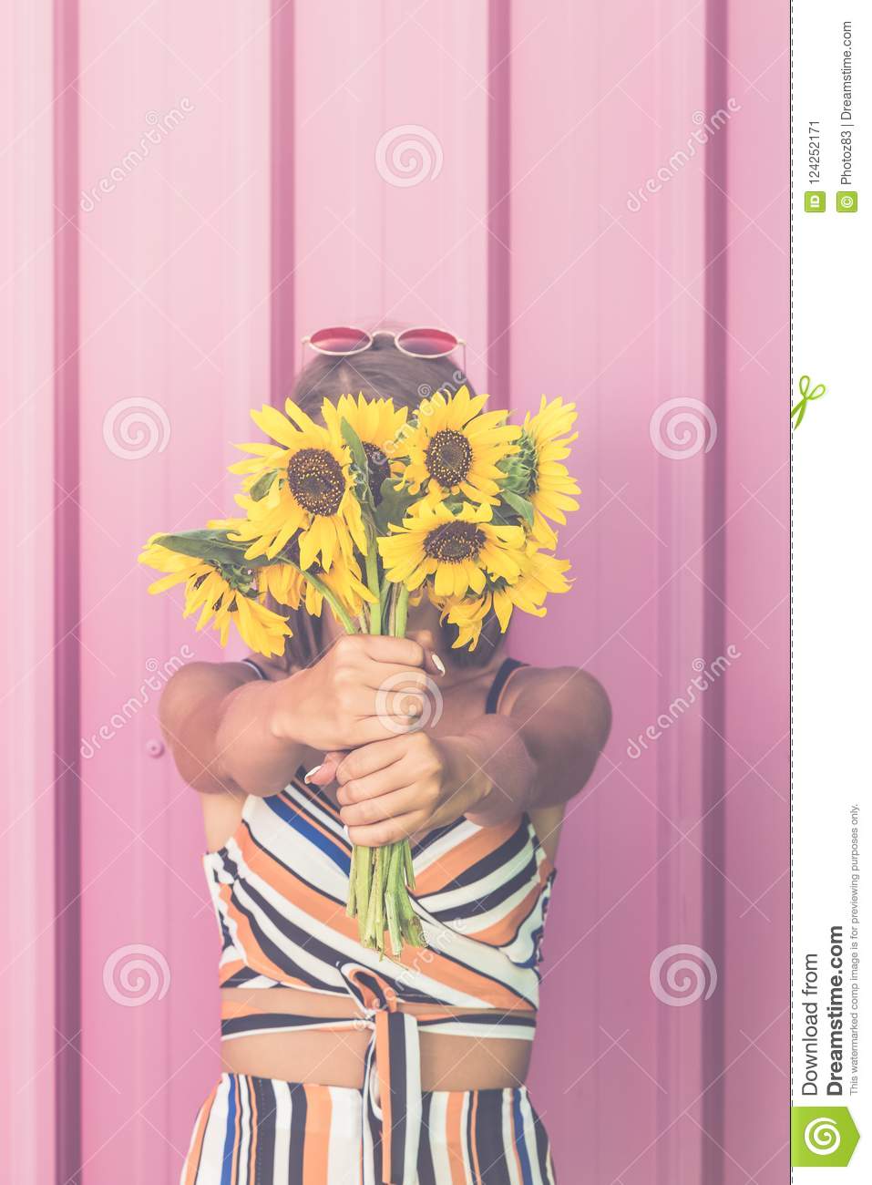 957x1300   Хипстерская девушка держит букет подсолнухов на лице на пастели Розовый фон. Stock Image - Изображение лица невесты: 124252171