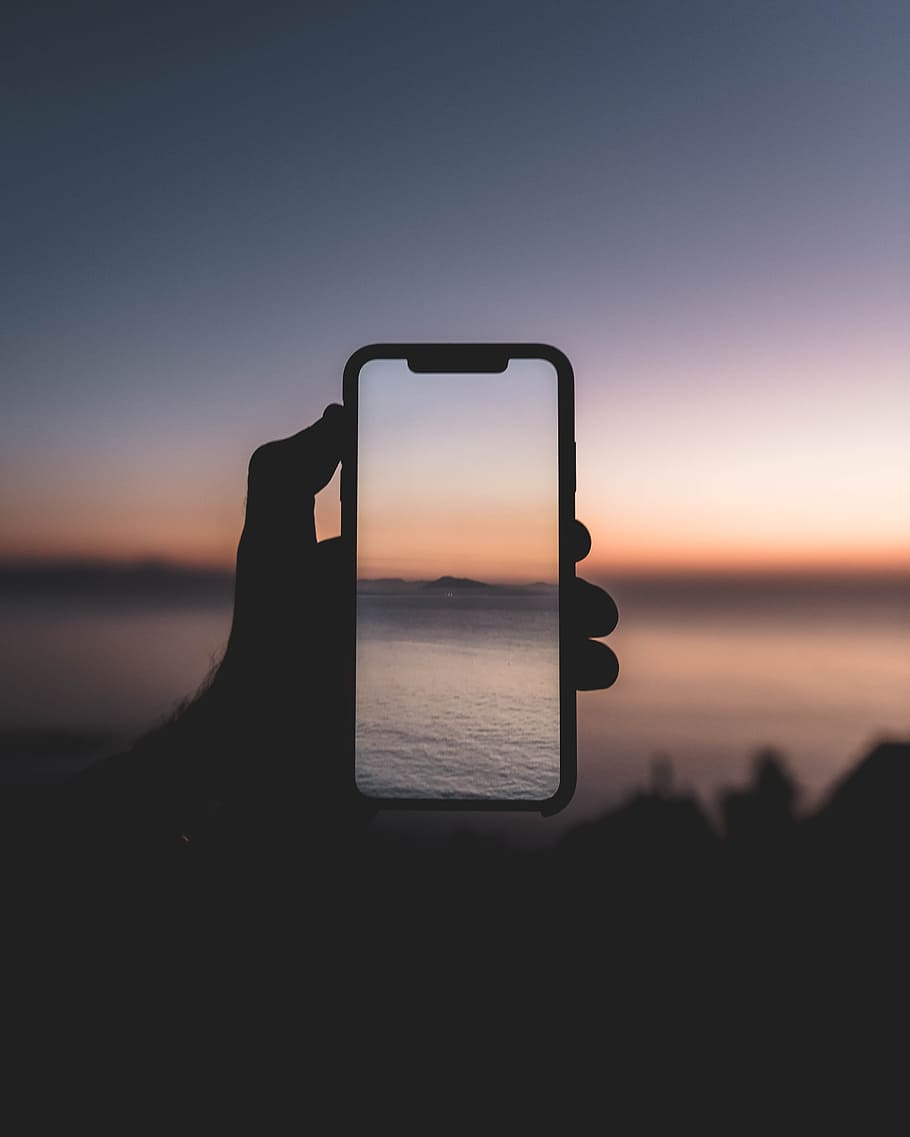 910x1137  HD обои: силуэт человека, фотографирующего водное пространство в руке телефона | Wallpaper Flare
